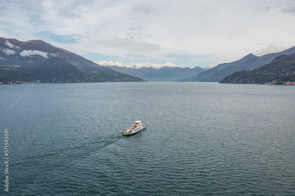 Aerial view of a small boat cruising along the coastline in Bellagio, a small town on Como Lake, Lombardy, Italy. Aerial view of a small boat cruising along the coastline in Bellagio, a small town on Como Lake, Lombardy, Italy.