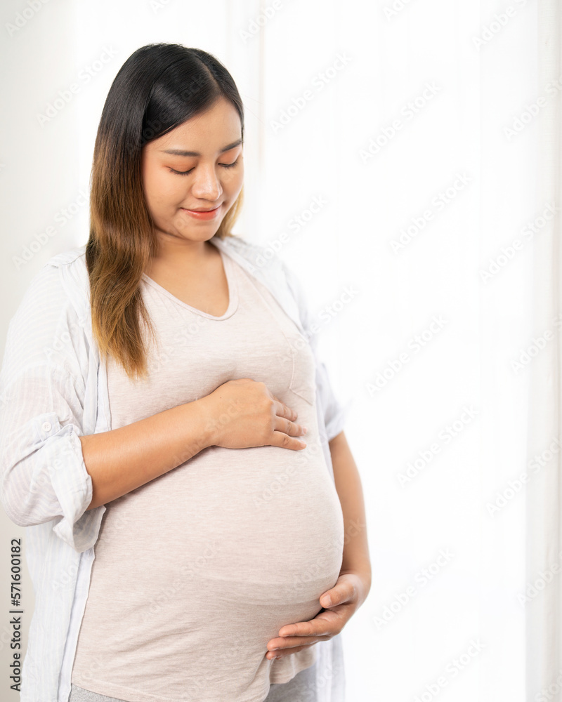 pregnant woman standing near window at home pregnant woman standing near window at home