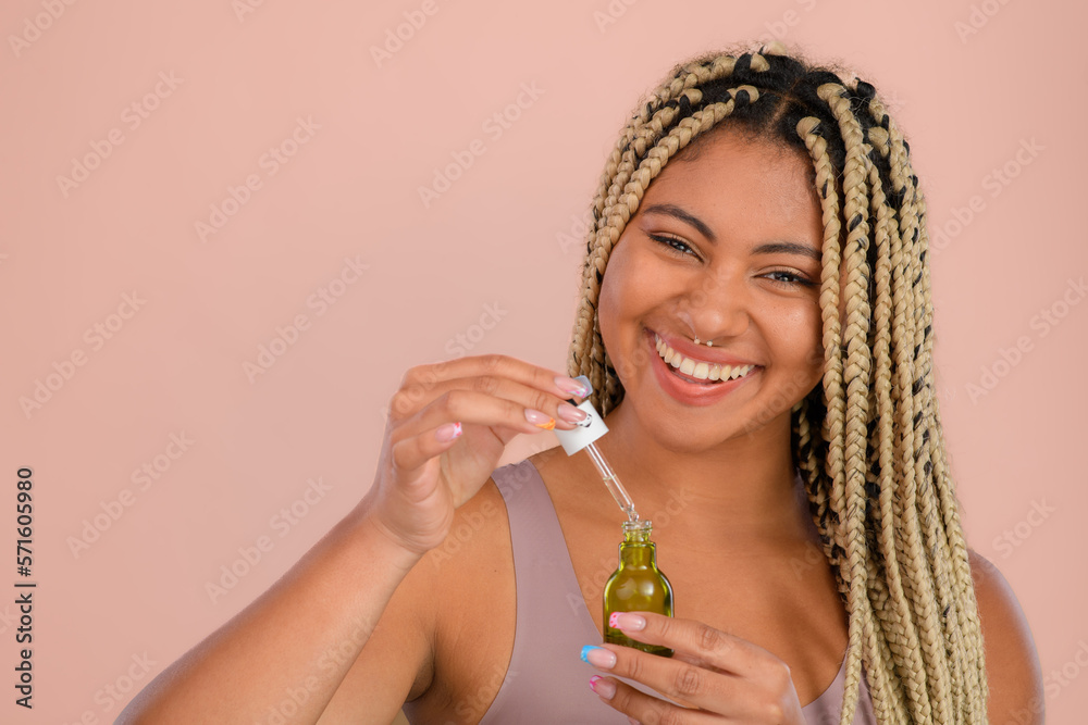 Portrait of young woman holding skincare serum drops in studio.Concept of beauty and skincare.