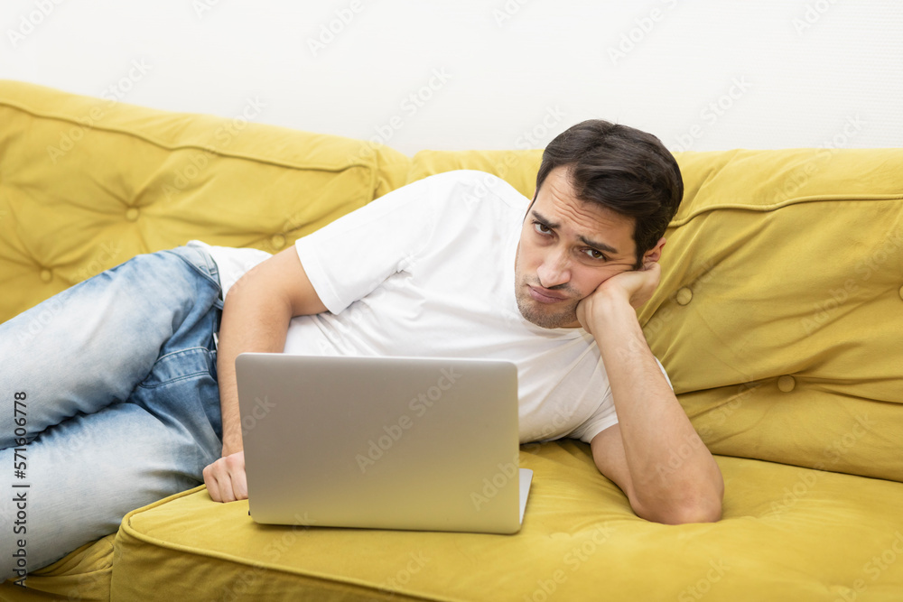 Upset and tired student sitting on the couch and studying online at home. Distance learning concept
Upset and tired student sitting on the couch and studying online at home. Distance learning concept