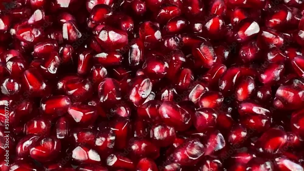 Rotating red fresh pomegranate arils at studio. Close-up of juicy seed pods of tropical fruit indoors. Rotation sweet tart taste ready to eat vegetarian food. Organic antioxidant. Healthy nutrition