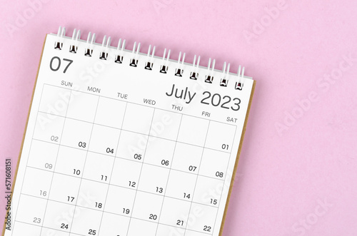 A July 2023 calendar desk for the organizer to plan and reminder isolated on pink background.