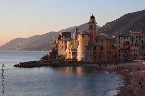 Camogli, Italy - January 27, 2023: Beautiful old mediterranean town at the sunrise time with illumination during winter days. People enjoying the evening at the beach with beautiful sunset background © yohananegusse