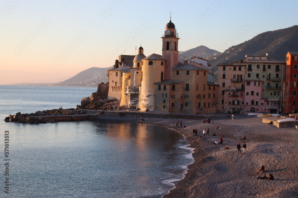Camogli, Italy - January 27, 2023: Beautiful old mediterranean town at the sunrise time with illumination during winter days.
People enjoying the evening at the beach with beautiful sunset background