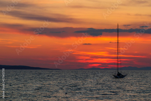 Sunset by the sea with sailing boat