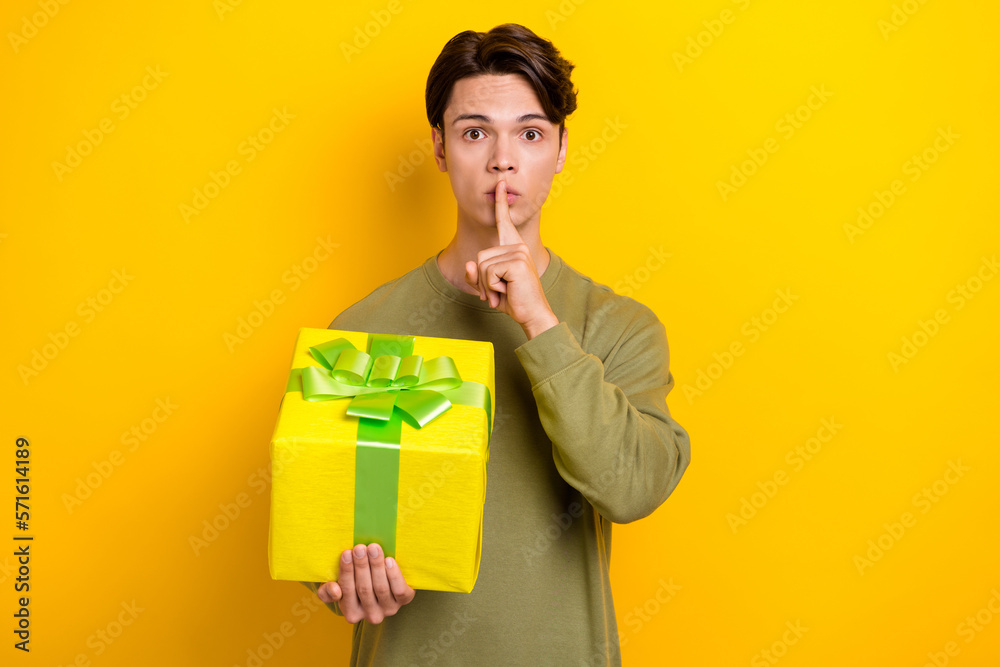 Photo of attractive man wear trendy clothes arm touch lips shh preparing surprise isolated on yellow color background Photo of attractive man wear trendy clothes arm touch lips shh preparing surprise isolated on yellow color background
