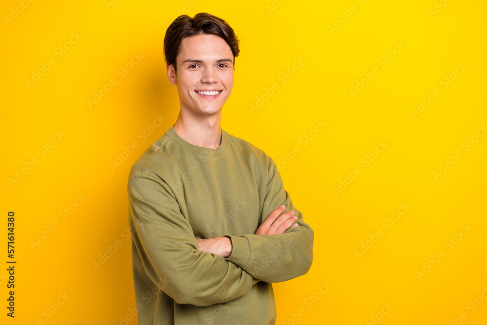 Portrait of cheerful half turned person crossed arms empty space ad isolated on yellow color background Portrait of cheerful half turned person crossed arms empty space ad isolated on yellow color background