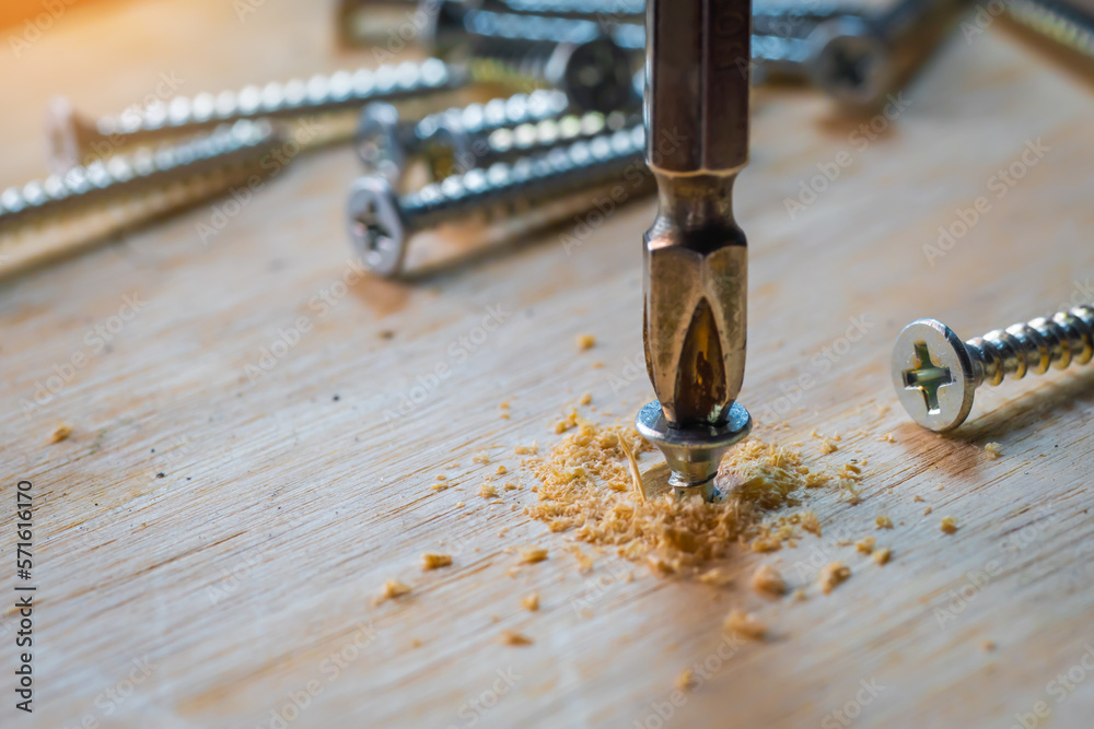 Carpenter use Cordless drill drive the screw on wooden plate with countersink bit to drill both a pilot hole ,DIY maker and woodworking concept. selective focus