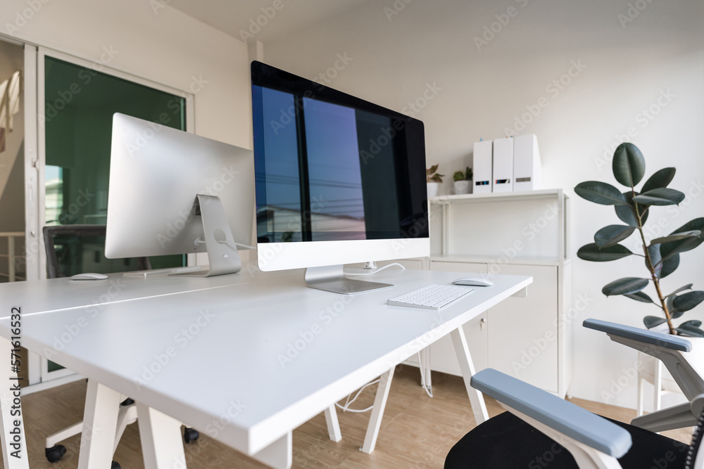 White table and chair with computer monitor and modern file cabinet in white home office White table and chair with computer monitor and modern file cabinet in white home office