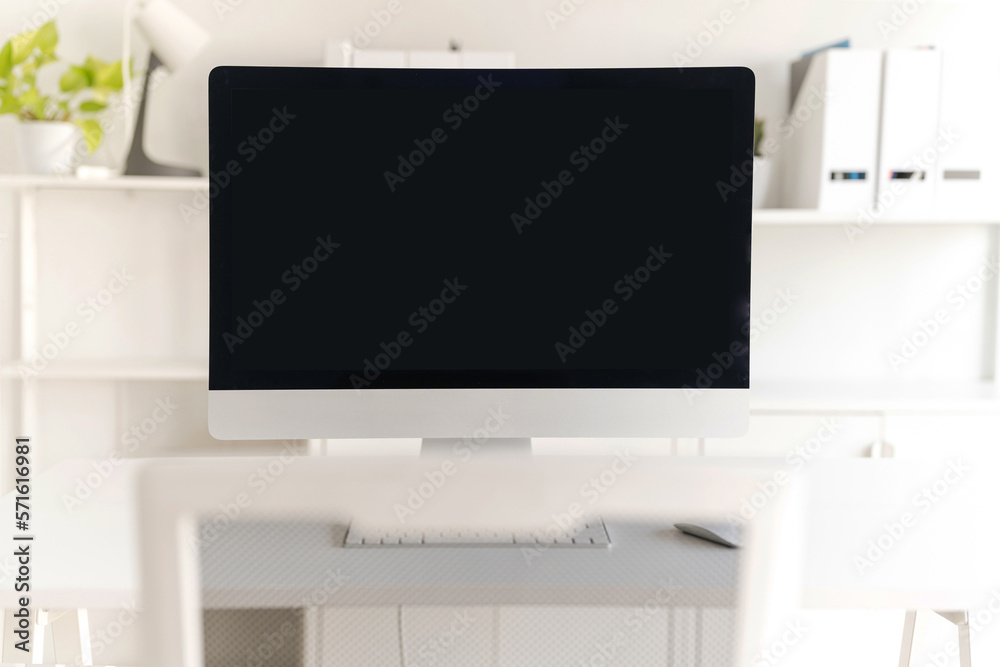 White table and chair with computer monitor and modern file cabinet in white home office