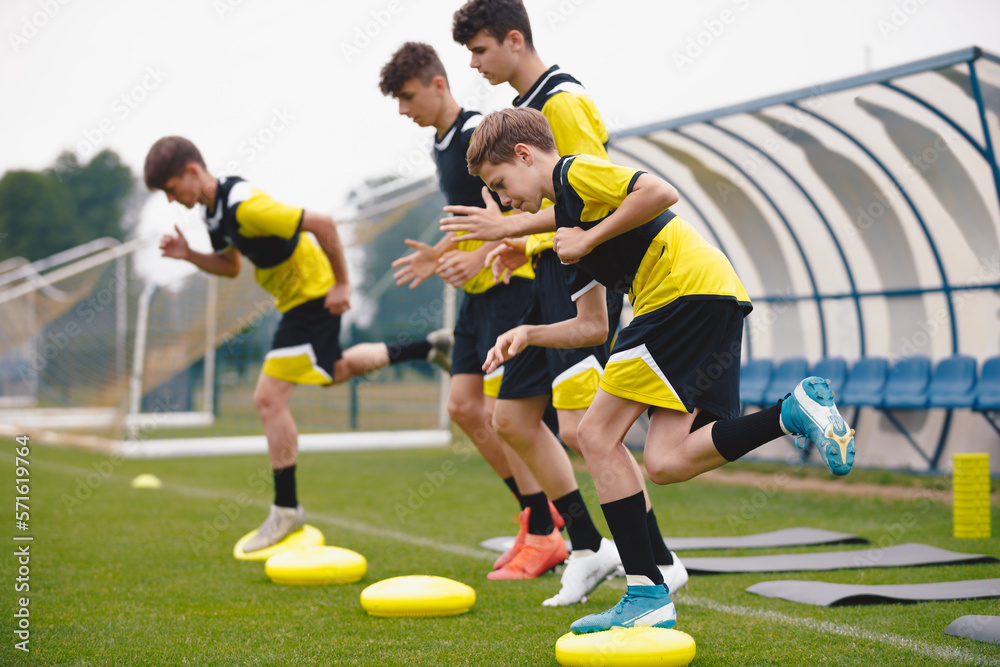 Football Balance Training. Youths on Stability Sports Training on Balance Cushions. Young Soccer Players Improving Core Strength, Balance and Stability Skills. Grass Football Field. Coaching Soccer