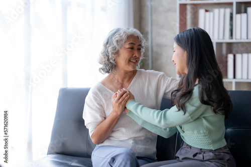 Asian mother and son spending vacation in living room Show your love for each other by embracing each other warmly and happily at home.