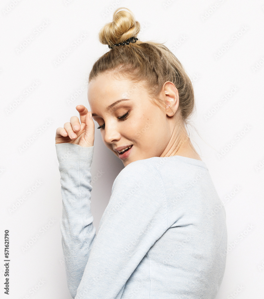 lifestyle, emotion and young people concept: smiling young woman with long blond hair dressed casual touches her face lifestyle, emotion and young people concept: smiling young woman with long blond hair dressed casual touches her face