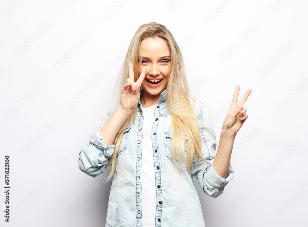 young woman with long blond hair wearing casual denim shirt smiling over white background