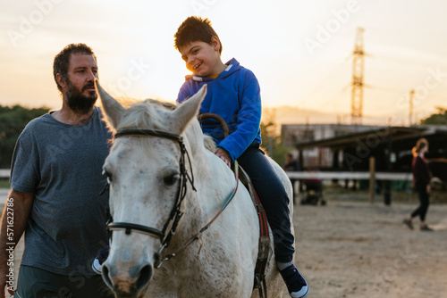 Physiotherapist working with a child with a disability in an equine therapy session.