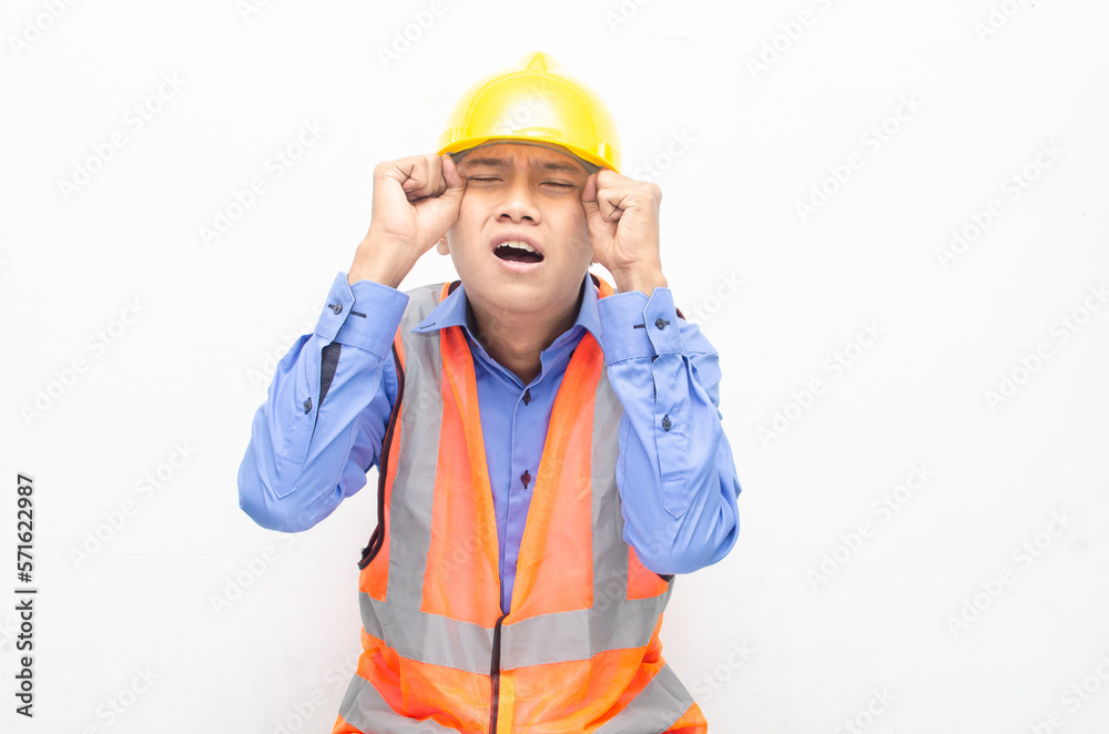 stressed over work concept illustrated by asian male construction worker in blue shirt, orange vest and yellow safety helmet with furious, mad, sad, angry expression. overworked concept stressed over work concept illustrated by asian male construction worker in blue shirt, orange vest and yellow safety helmet with furious, mad, sad, angry expression. overworked concept