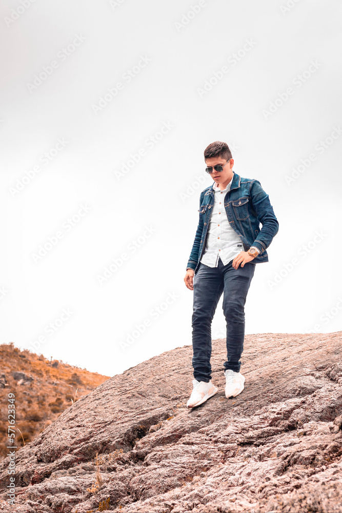 Hombre camina bajando una montaña con gafas de sol con nubes Hombre camina bajando una montaña con gafas de sol con nubes