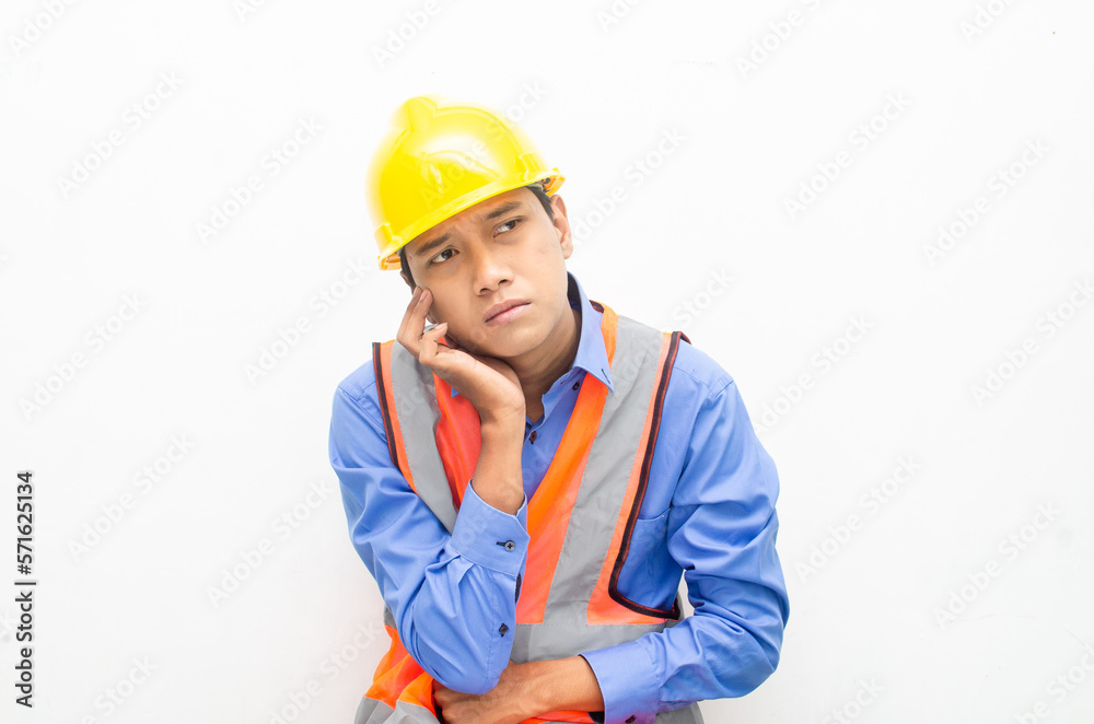 stressed over work concept illustrated by asian male construction worker in blue shirt, orange vest and yellow safety helmet with furious, mad, sad, angry expression. overworked concept stressed over work concept illustrated by asian male construction worker in blue shirt, orange vest and yellow safety helmet with furious, mad, sad, angry expression. overworked concept