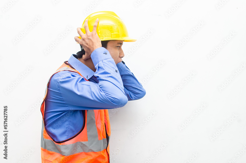 side view of stressed over work concept illustrated by asian male construction worker in blue shirt, orange vest and yellow safety helmet with furious, mad, sad, angry expression. overworked concept side view of stressed over work concept illustrated by asian male construction worker in blue shirt, orange vest and yellow safety helmet with furious, mad, sad, angry expression. overworked concept