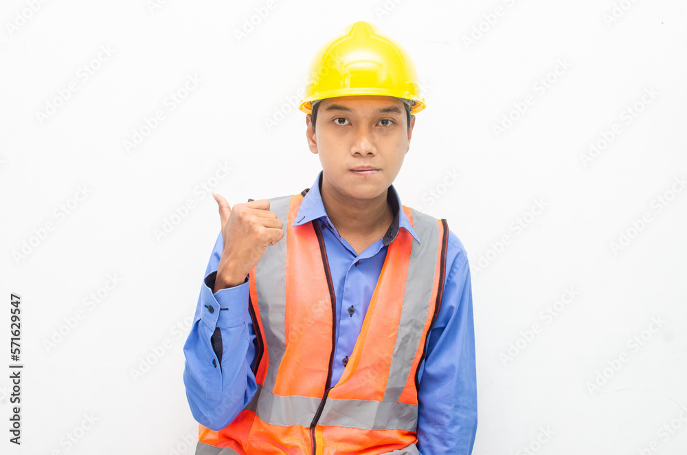 asian construction worker wearing yellow safety helmet and vest smiling and pointing finger with happy and shocked expression. billboard model advertisment concept. asian construction worker wearing yellow safety helmet and vest smiling and pointing finger with happy and shocked expression. billboard model advertisment concept.