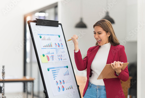 Portrait young businesswoman presentation marketing and profit with confident at office, investment and seminar for planning of finance, business woman standing explaining chart and graph.