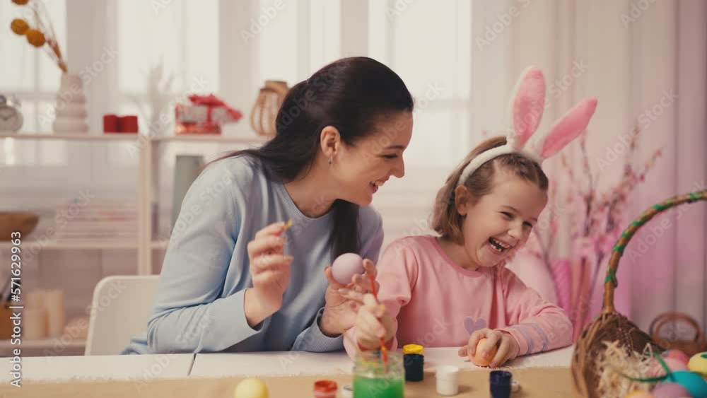 Mom and little daughter decorating eggs, preparation for Easter celebration Mom and little daughter decorating eggs, preparation for Easter celebration