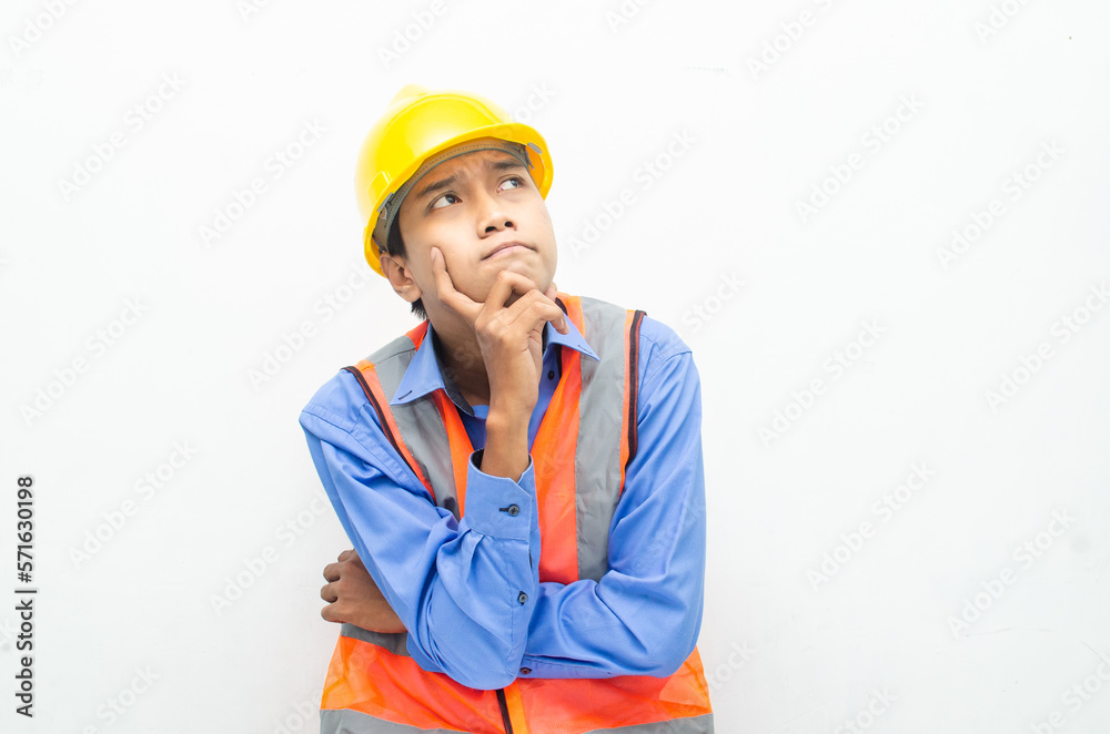 thoughtful asian male construction worker in pensive mood doing thinking and wondering gesture.