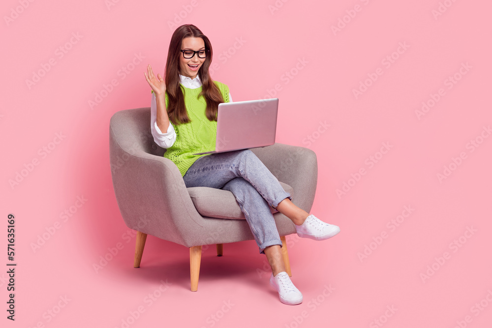 Full length photo of lovely nice girl with straight hairdo dressed green vest hold laptop say hi isolated on pink color background Full length photo of lovely nice girl with straight hairdo dressed green vest hold laptop say hi isolated on pink color background
