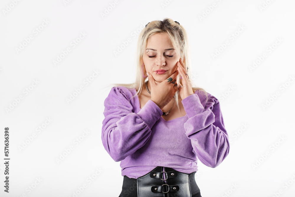 Portrait of cheerful woman wearing blouse standing isolated over white background touching cheek closed eyes, suffering from a toothache. Tries to get relief by touching chin. Dentist concept.