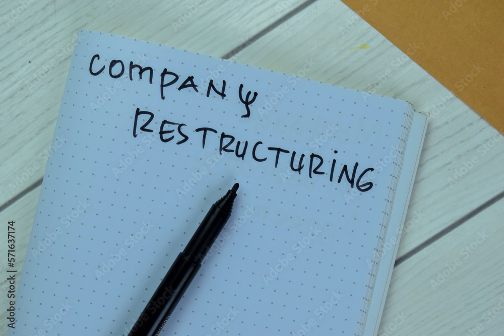 Concept of Company Restructuring write on book isolated on Wooden Table. Concept of Company Restructuring write on book isolated on Wooden Table.