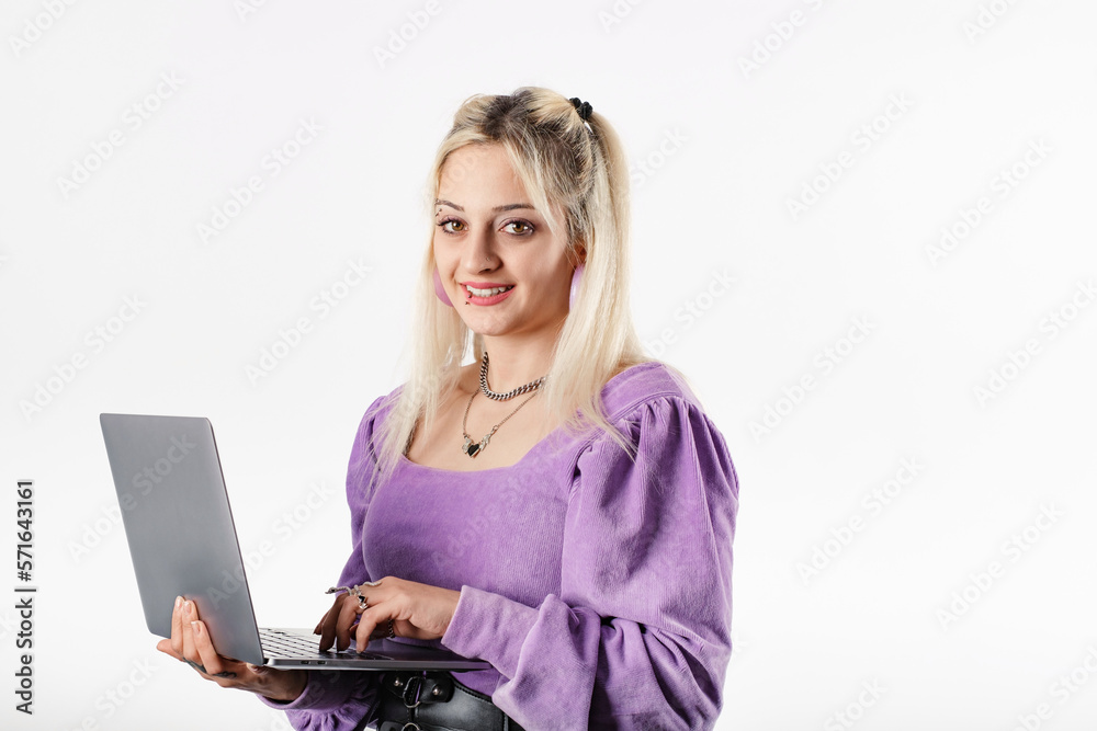 Naklejka premium Cheerful blonde woman blouse isolated over white background holding a laptop, smiling at the camera with a confident expression. Typing on laptop keyboard. Creating web design or digital work.