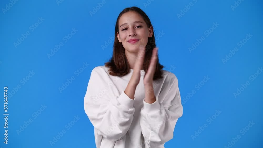 4k slow motion video of excited girl clapping in hands on blue background. 4k slow motion video of excited girl clapping in hands on blue background.
