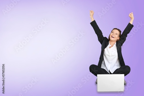 Happy young smart woman posing with laptop on background