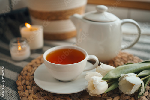 Cup of tea with a teapot, flowers and candles, atmospheric tea party