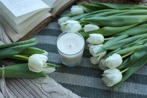 Fototapeta Naklejka Na Ścianę i Meble -  Candle, tulips and open book in home interior