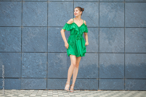 Young beautiful brunette model in green dress