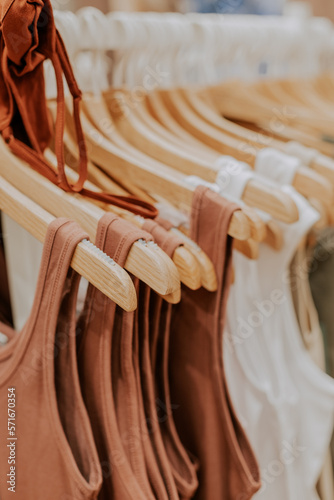 Multi-colored T-shirts hang on hangers.