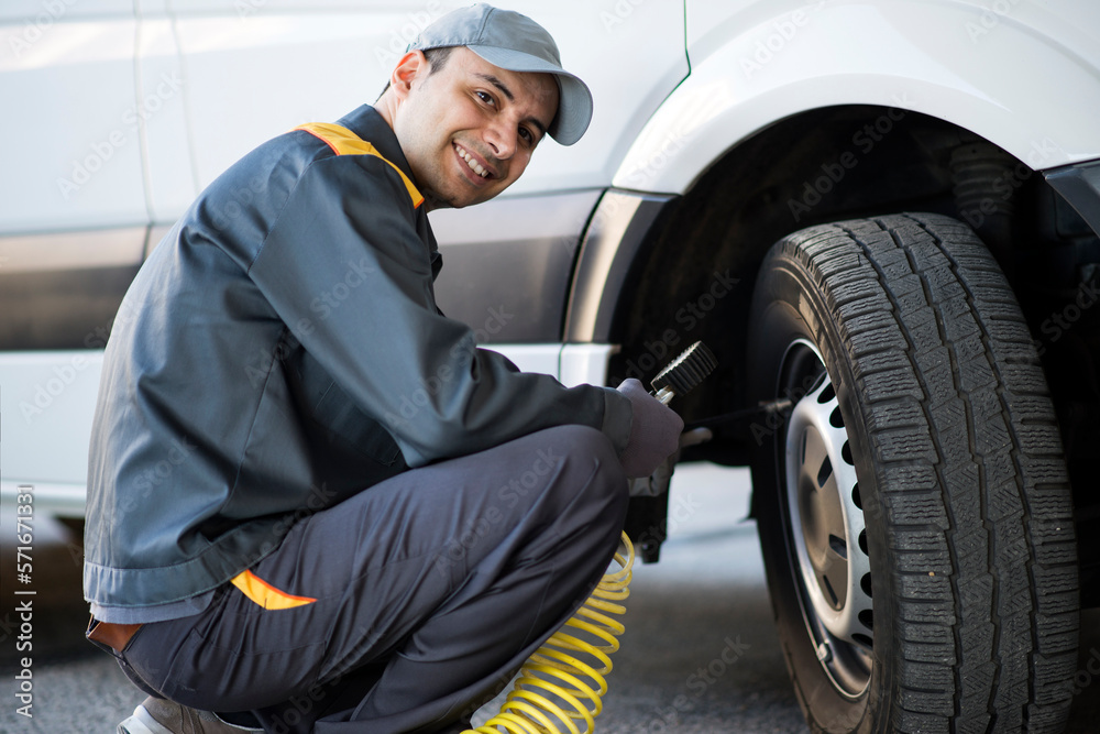 Mechanic checking the pressure of a van tire Mechanic checking the pressure of a van tire