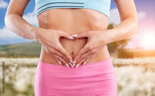 Young fitness woman with heart hand sign