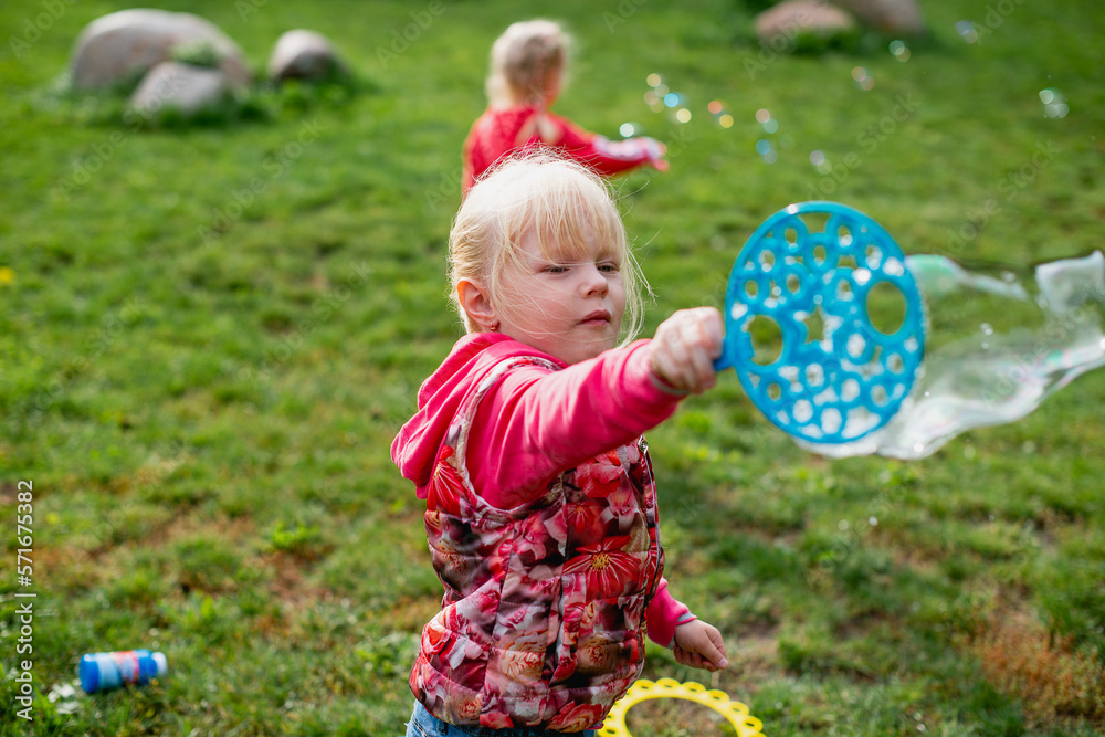 little girl, blonde, playing in the meadow, and blows a bubble. little girl, blonde, playing in the meadow, and blows a bubble.
