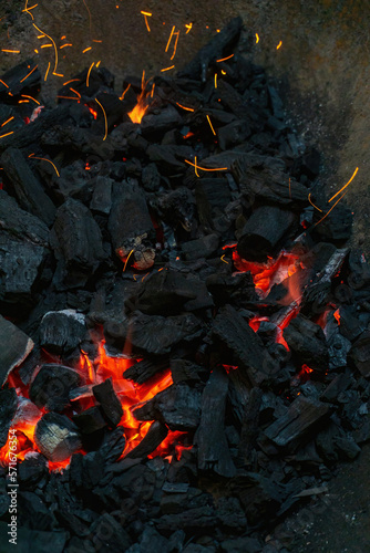 Coals with sparks in a huge old metal grill