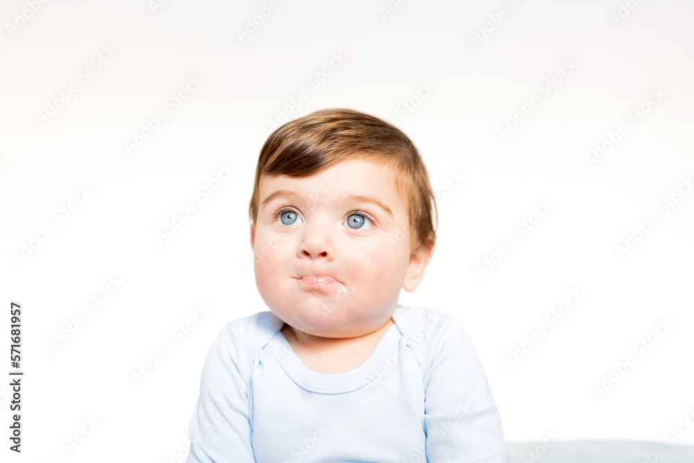 portrait of baby less than one year old with big blue eyes, blond hair. neonate making gesture with mouth, close-up portrait portrait of baby less than one year old with big blue eyes, blond hair. neonate making gesture with mouth, close-up portrait