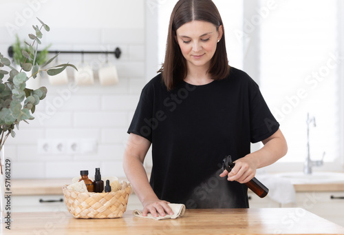 Young woman cleans the kitchen with eco products. photo