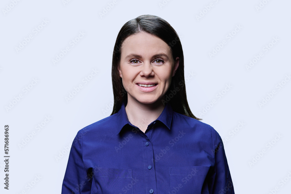 Headshot portrait of young woman looking at camera on white background Headshot portrait of young woman looking at camera on white background