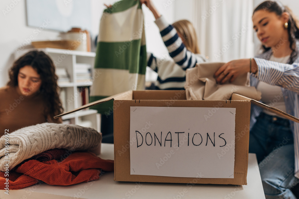 Ταπετσαρία Three caucasian woman give away clothes for charity
