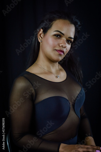 Portrait of a serene and positive young Brazilian woman, against a dark background © sebastianosecondi