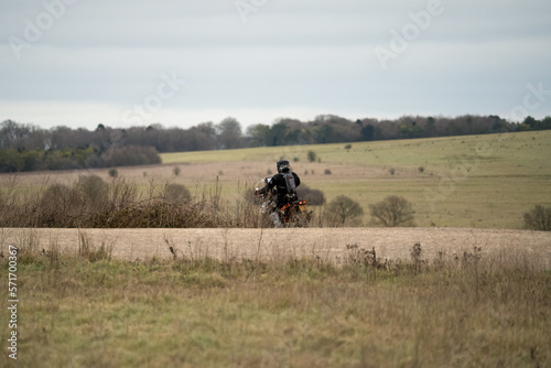 a motor cyclist (biker) riding their sports motorbike along a stone track