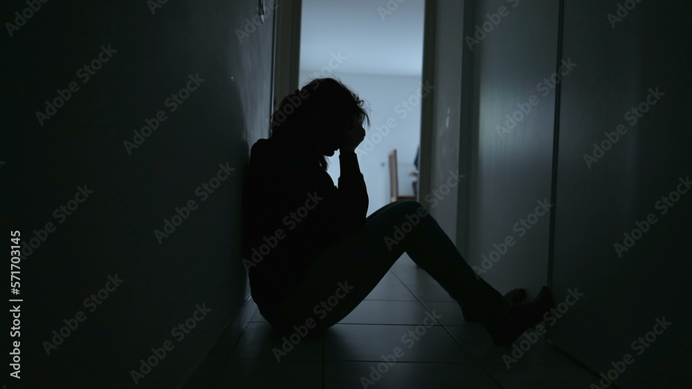 Depressed woman sitting on floor. Sad unhappy person holding her forehead suffering from mental illness - obrazy, fototapety, plakaty 
