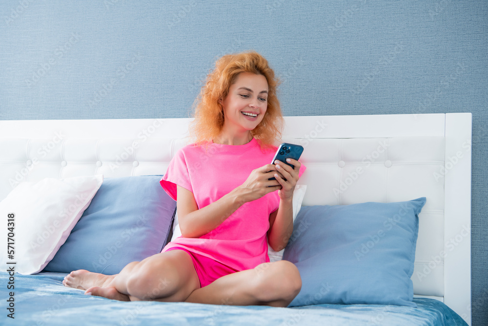 happy girl relax at home and texting on phone. girl texting on phone on the bed. phone texting happy girl relax at home and texting on phone. girl texting on phone on the bed. phone texting