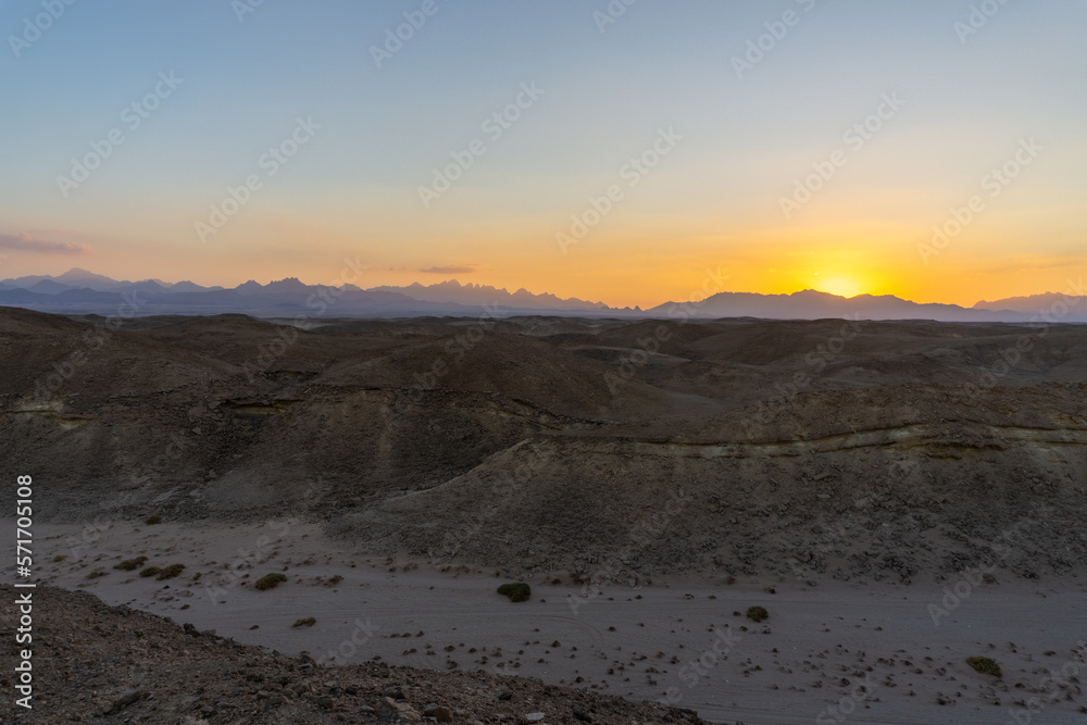 Sunset in the Hurghada desert, with the desert mountains on the horizon Sunset in the Hurghada desert, with the desert mountains on the horizon
